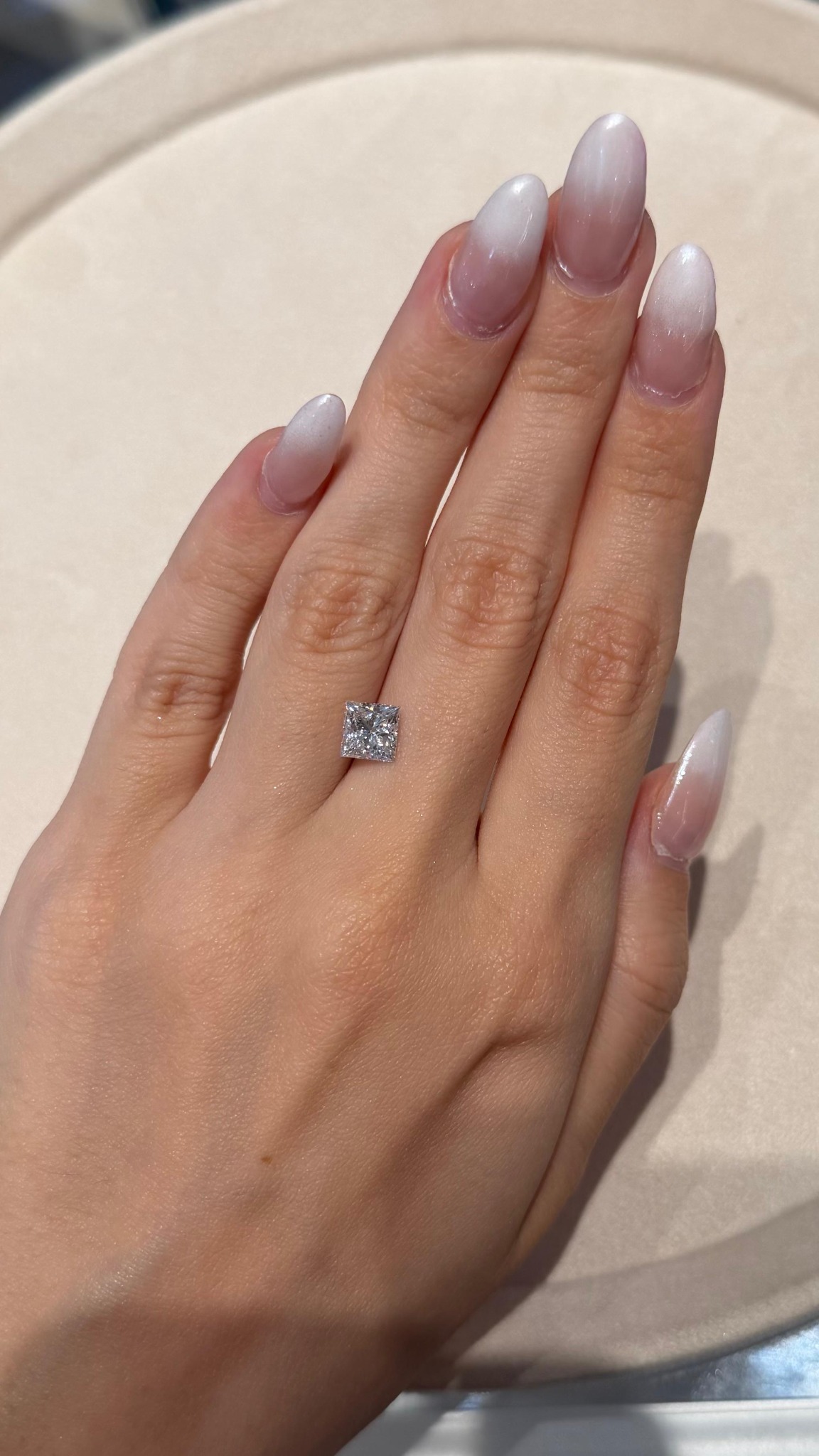 Diamante de forma cuadrada sobre una mano, fotografiado a la luz natural