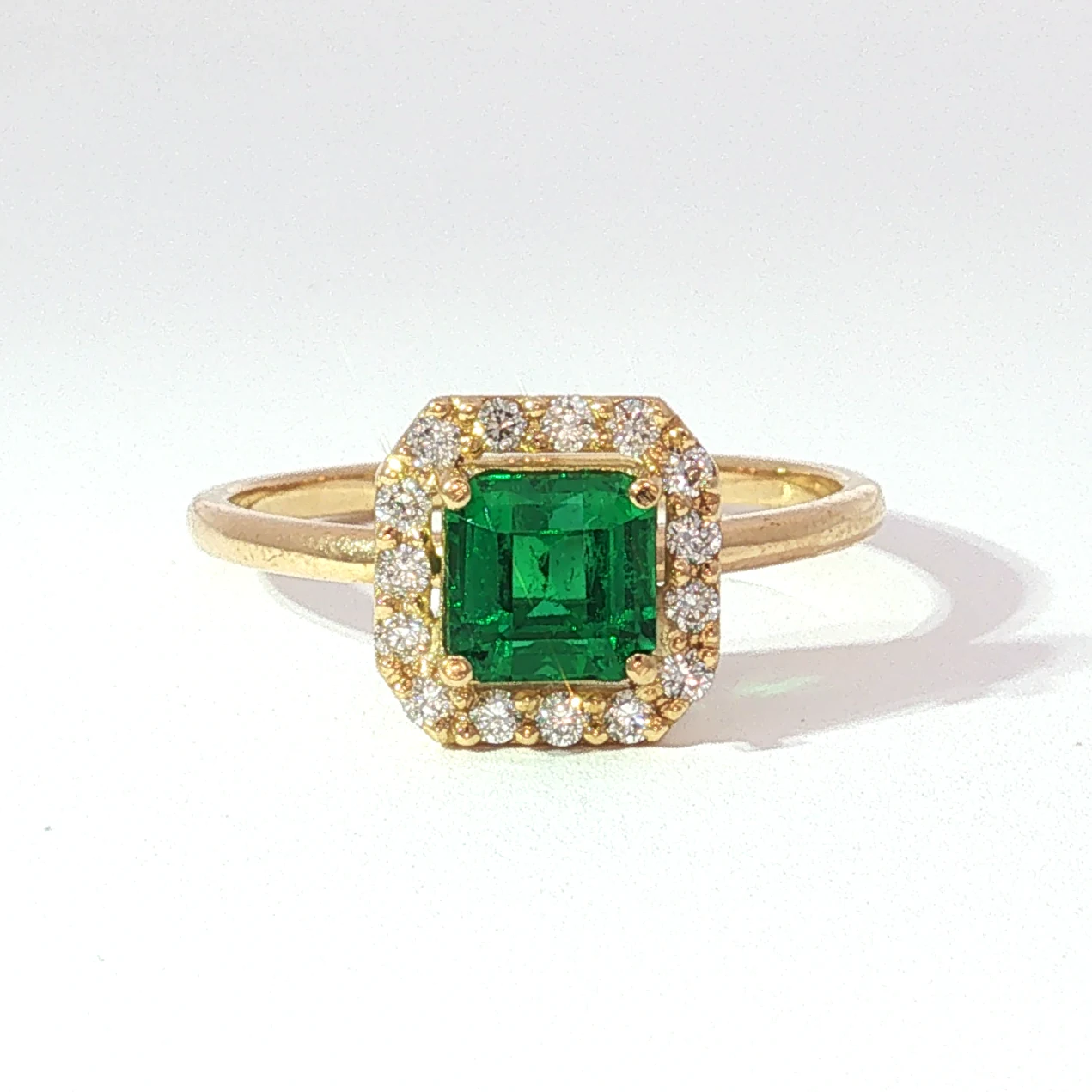 Anillo de esmeralda rectangular con halo de diamantes